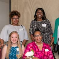 6 people pose at table